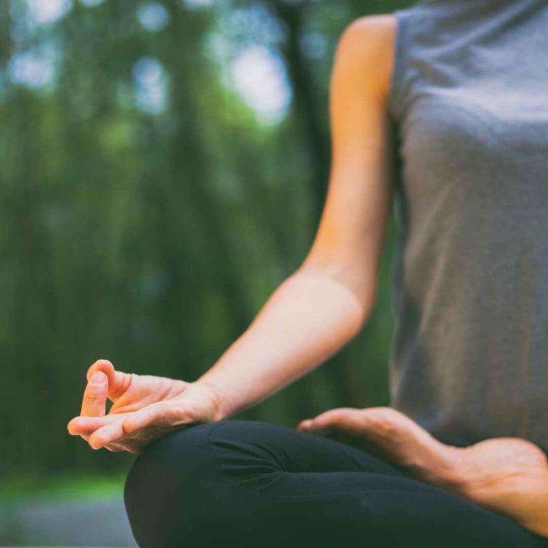 Person praktiserer meditation i naturen som en metode til at reducere præstationsangst.